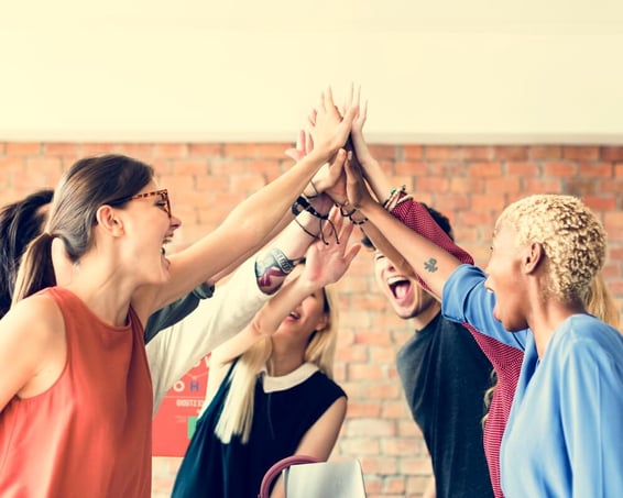 Diverse team hgih - five in a modern office to boost employee engagement.