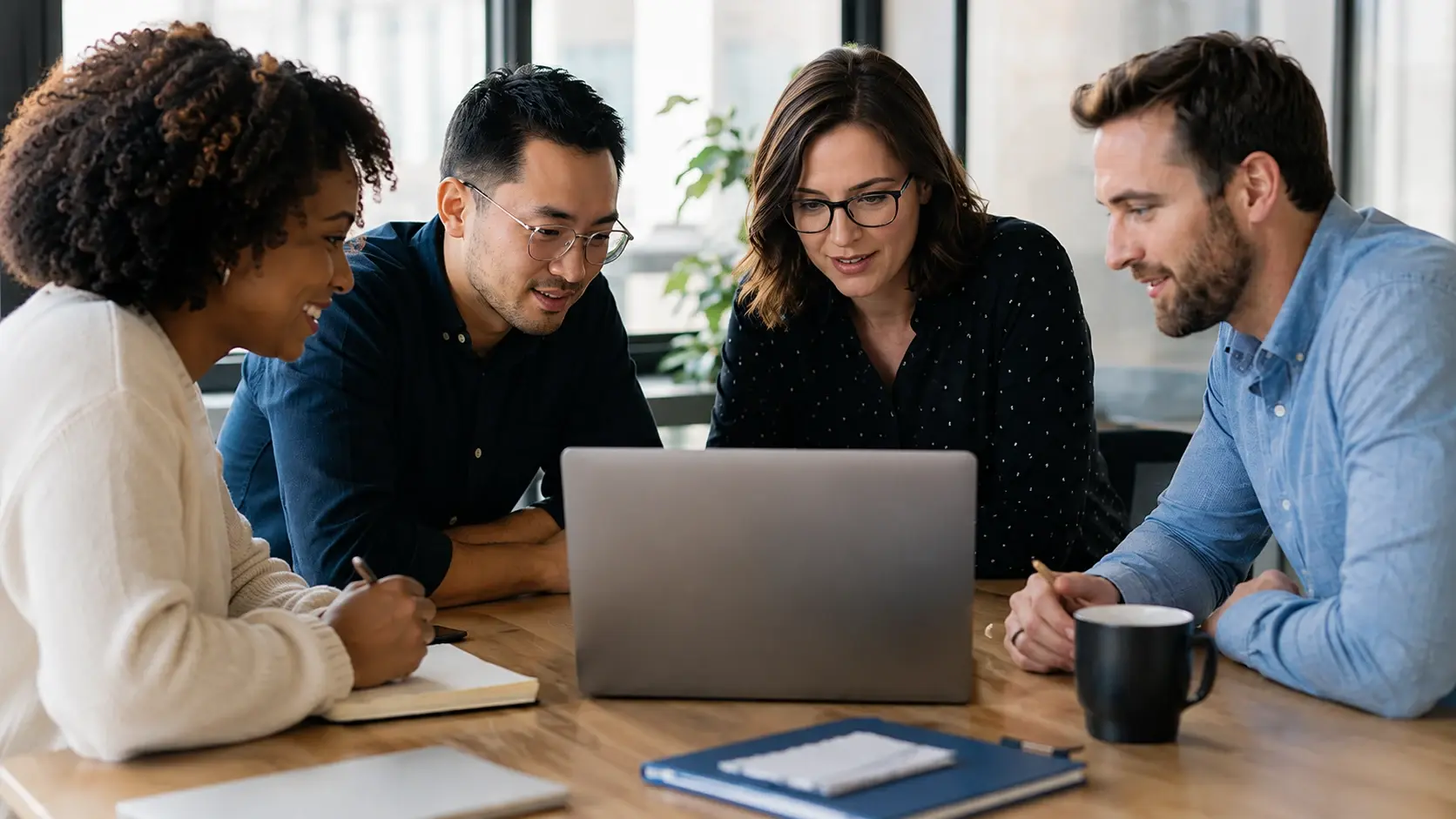 Team collaborating around a laptop